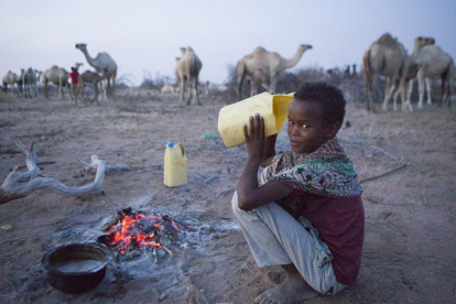 Un niño pastor de camellos bebe leche de uno de los animales que cuida en el desierto del norte de Kenia.