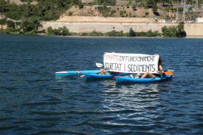 Plano general de dos participantes en la 'Marxa dels Sediments' desplegando una pancarta.