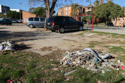 Brossa i restes d'obres abocades al costat de la pista esportiva.