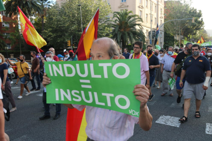 Un hombre muestra un cartel donde se lee 'indulto igual a insulto' durante una manifestación contra los indultos.