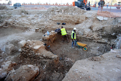 Dos treballadors en l'obra d'urbanització de la plaça de la Catedral de Tortosa i la museïtzació de les restes arqueològiques.