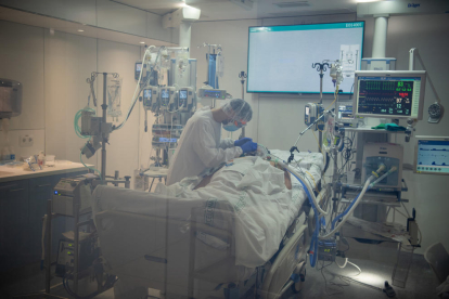 Un metge atenent amb un pacient amb covid-19 a l'Àrea de Vigilància Intensiva (AVI) de l'Hospital Clínic de Barcelona.