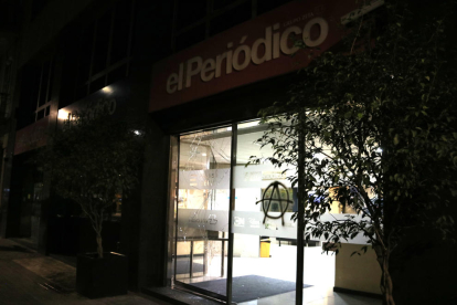 Els vidres de la porta de la redacció d''El Periódico' esbotzats durant la tercera nit d'aldarulls a Barcelona.