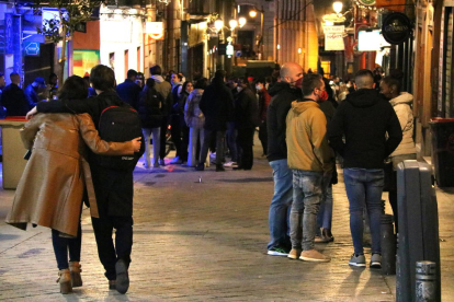 Grups de gent pels carrers del centre de Madrid passades les 23 hores.