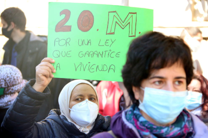 Una mujer levanta una pancarta a la manifestación del movimiento por la vivienda.