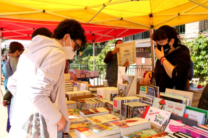 Persones comprant llibres en una de les parades del parc Sant Jordi de Reus.