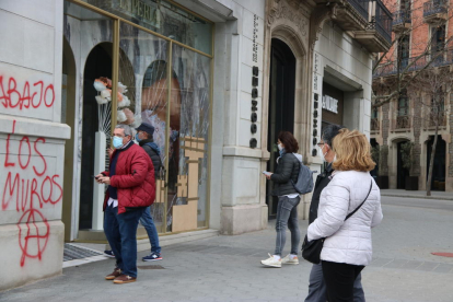 Vianants curiosos miren les destrosses causades a les botigues del Passeig de Gràcia.