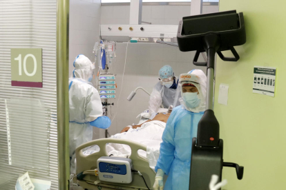 Un pacient amb covid-19 rep atenció a un box de l'UCI de l'Hospital de Mataró.