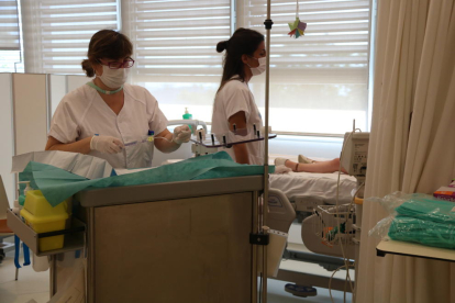Imatge de dues infermeres atenent un nen fent tractament a l'Hospital de Dia de Vall d'Hebron