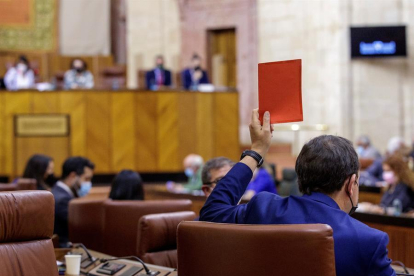 Un diputado de Vox indica el sentido negativo de su voto a una votación al parlamento andaluz.