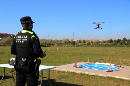 Un agent de la Guàrdia Urbana de Tarragona fent aterrar el dron del cos policial durant una demostració a Campclar.