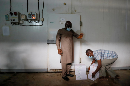 Un trabajador se prepara para almacenar cajas de vacunas en una cámara frigorífica en Ghana.