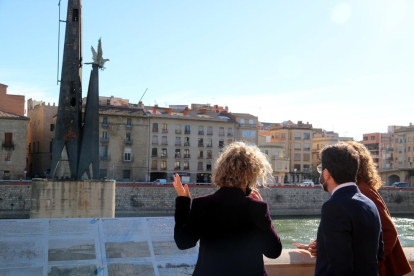 Plano abierto del vicepresidente Pere Aragonès, la consellera de Justicia Ester Capella y la alcaldesa de Tortosa Meritxell Roigé, de espaldas, mirando el monumento franquista.