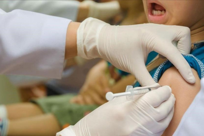 Una niña se vacuna de la gripe.