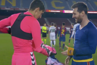 Edgar Badia le entrega la camiseta a un Messi feliz.
