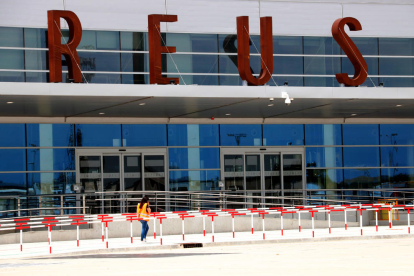 Una operària que passa per davant la nova terminal de l'Aeroport de Reus.