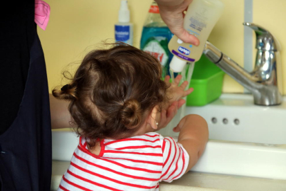 Una niña limpiándose las manos con gel.