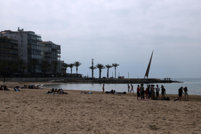 Personas disfrutando del buen tiempo en una de las playas de la zona turística de Salou.