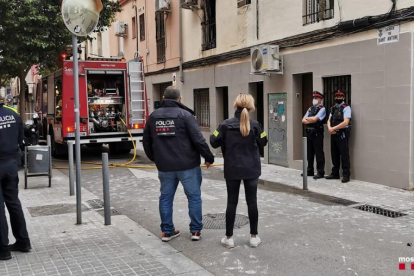 Efectivos de diferentes cuerpos de seguridad delante de un camión de Bomberos durante el incendio en un piso de l'Hospitalet de Llobregat.