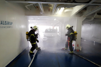 Els Bombers sufocant el simulacre d'incendi del cotxe elèctric al ferri de Baleària