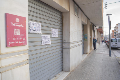 Imatge de la porta d'entrada al teatre amb els cartells dels joves del barri reclamant l'obertura.