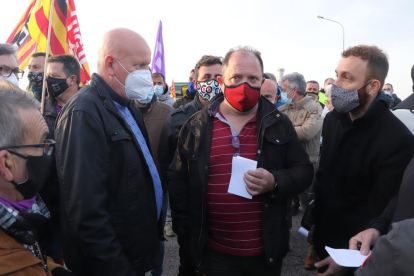 El cap de producció d'IQOXE, Ferran Cabré -a l'esquerra de la imatge-, discutint amb els treballadors en vaga després d'haver-los entregat la carta.