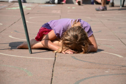 Imagen de archivo de una niña estirada al suelo llorando.