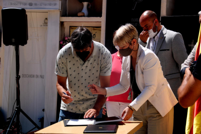 Pla mitjà de l'alcalde de Miravet, Antoni Llambrich, i la consellera de Justícia, Lourdes Ciuró, signant la cessió de restes òssies.