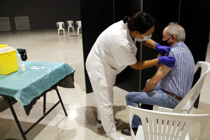 Imatge d'una infermera vacunant un home.