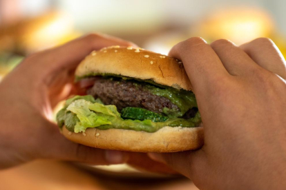 Imagen de archivo de una persona comiéndose una hamburguesa.