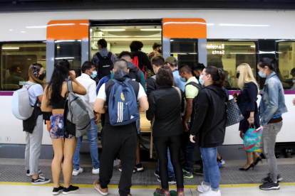 Un numeroso grupo de gente intenta entrar a un tren en la segunda jornada de huelga de maquinistas de Renfe a la estación de Barcelona-Sants.