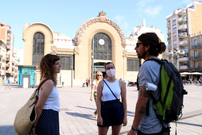 Tres jóvenes, dos de ellas sin mascarillas, charlando en la plaza Corsini de Tarragona, en el primer día sin obligatoriedad de llevar mascarillas.