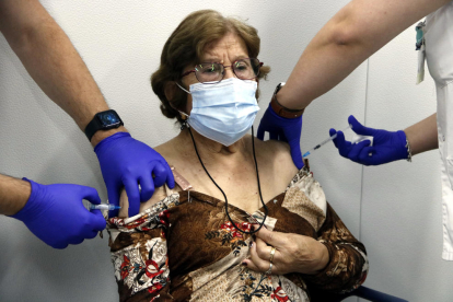 Imatge d'una senyora a qui li posen de forma simultània la vacuna de la grip i la tercera dosi de la Covid-19.