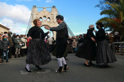 Los vecinos de Amposta vestidos de época bailando jotas en el marco de la recreación histórica de la inauguración del Puente Colgante.