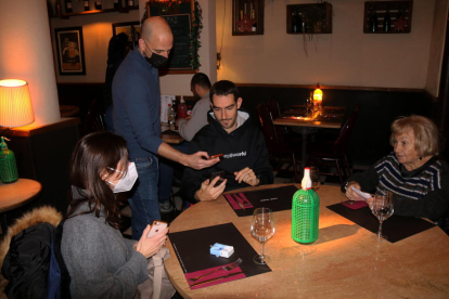 Un restaurador demanant comprovant el passaport covid en un bar de Gràcia.