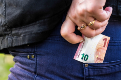 Imatge d'arxiu d'una persona ficant-se diners a la butxaca.