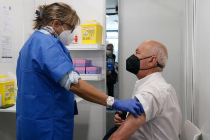 Una enfermera habla con un hombre justo después de que reciba la vacuna al punto habilitado en Feria de Barcelona.