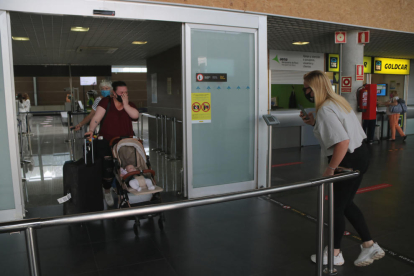 Pla obert d'una família que coneix per primera vegada la seva fillola, aquest dimarts al migdia a la Terminal d'arribades de l'Aeroport de Reus.