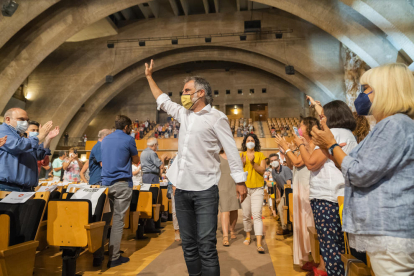 El presidente de Òmnium Cultural, Jordi Cuixart, entrando al auditorio del Palau Firal i de Congressos de Tarragona mientras los asistentes al acto lo aplauden.