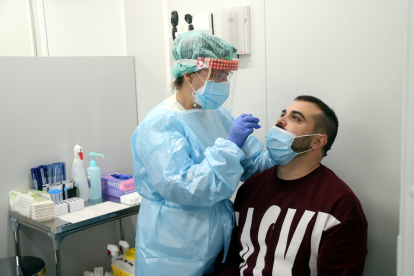 Una infermera fent un test d'antígens a un pacient.