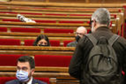 El presidente del Gobierno, Pere Aragonès, y el diputado de la CUP Carles Riera, antes de empezar un pleno en el Parlamento.