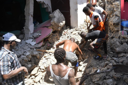 Un grupo de personas remueve escombros tras el terremoto que afectó al país.