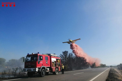Un camió i d'una avioneta dels Bombers de la Generalitat descarregant aigua sobre l'incendi de l'Ametlla de Mar.