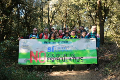 Participants en la caminada reivindicativa fins l'ermita de Puigcerver d'Alforja amb una pancarta en defensa del territori. Imatge del 19 de desembre de 2021 (Horitzontal).