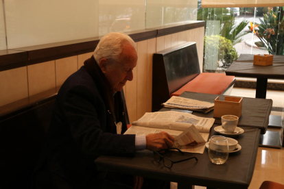 Un client llegint un diari al restaurant de l'hotel Class de Valls.