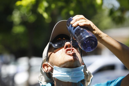Iatge de archivo de un joven bebiendo agua en la calle.