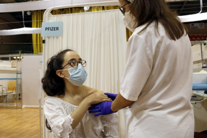 Mercedes Ferreira, de 18 años, recibiendo la vacuna contra la covid-19 en el Pabellón Once de Septiembre de Lérida.