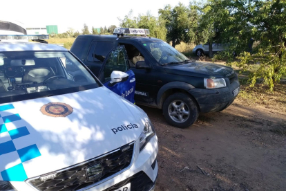 Vehicles del servei de guarda rural i la Policia Local de Constantí en un camp d'avellanes.
