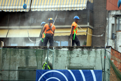 Operarios trabajando en el derribo de un edificio.