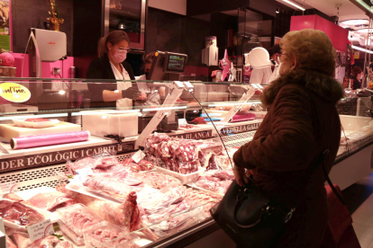 Una carnicera se atienen una compradora en un puesto del Mercado Central de Tarragona pocos días antes de Navidad.